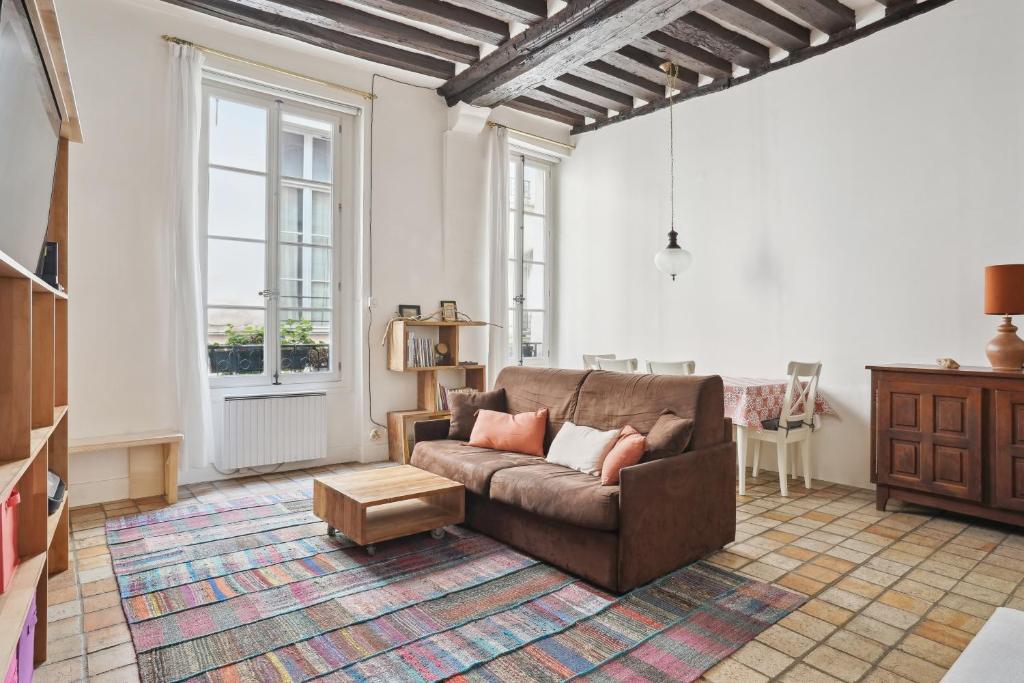 a living room with a couch and a table at Appartement au coeur du Marais à Paris by Weekome in Paris
