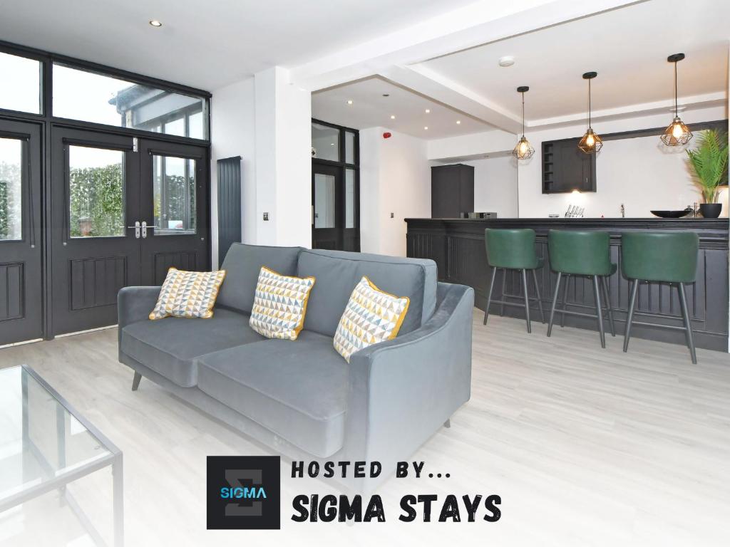 a living room with a couch and a kitchen at The Pub - By Sigma Stays in Crewe