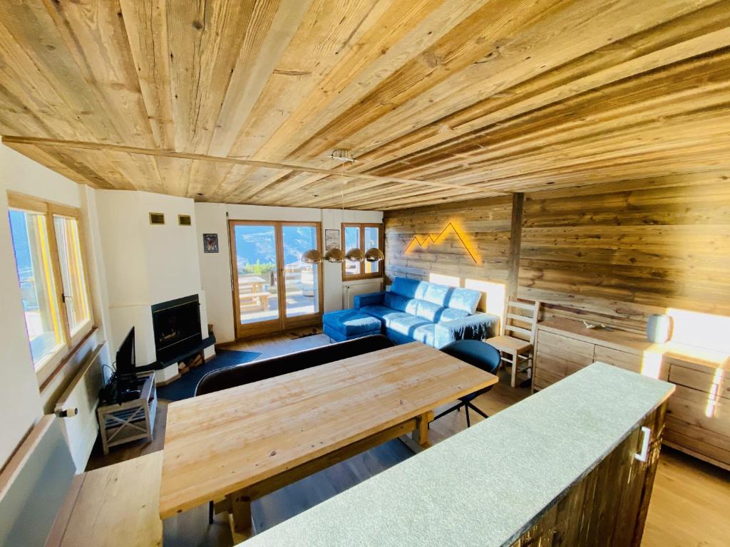 een woonkamer met een blauwe bank en een houten plafond bij Fontanettaz V 007 - MOUNTAIN & VIEW apartment 8 pers in Veysonnaz
