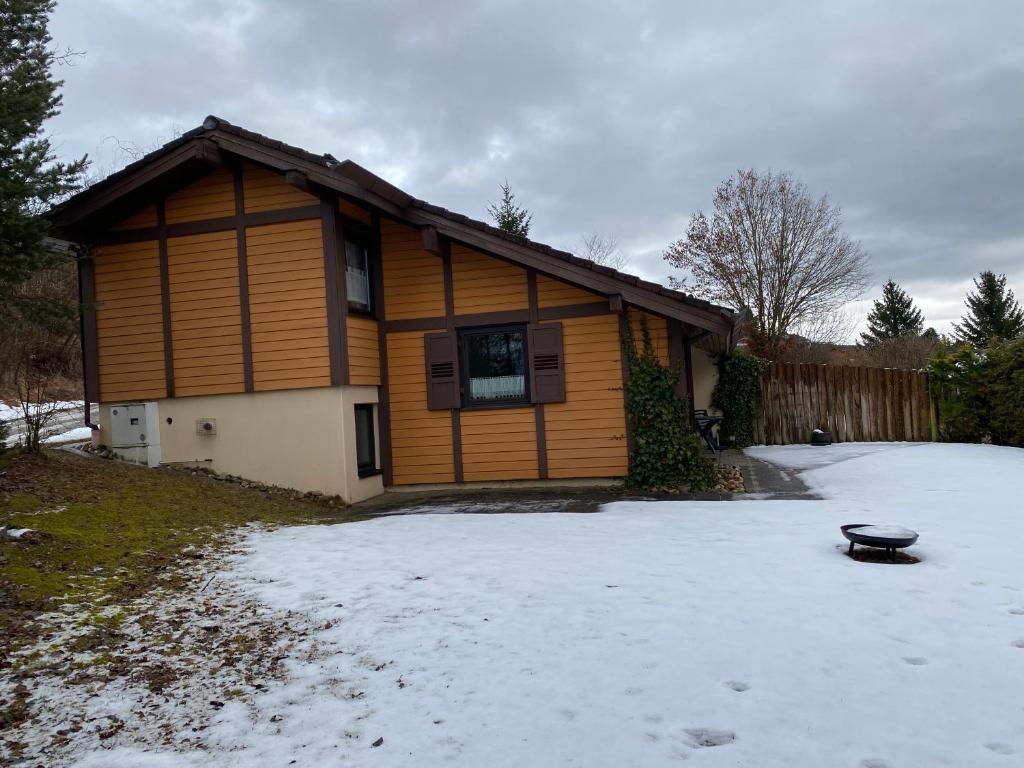 ein Haus mit Schnee davor in der Unterkunft Ferienhaus Feriendorf Kurort Bad Dürrheim in Bad Dürrheim