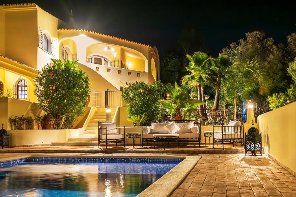 une villa avec une piscine la nuit dans l'établissement Casa Lusitania 19, à Faro
