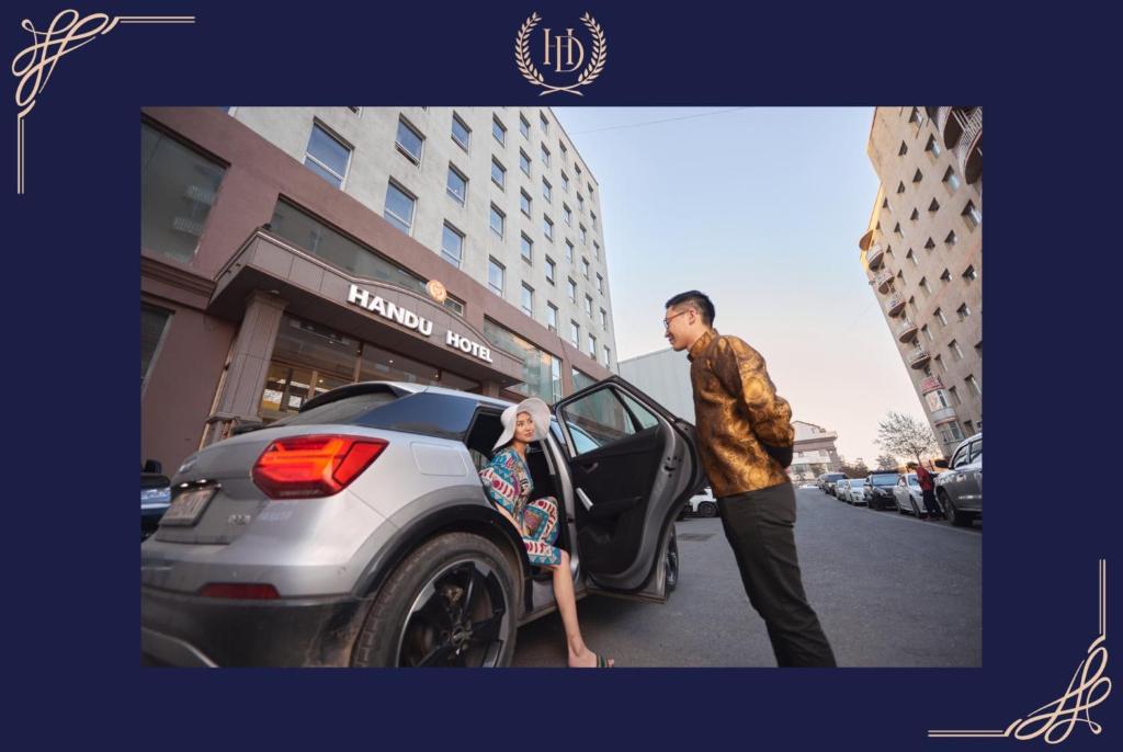 un hombre y una mujer saliendo de un coche en Handu Hotel en Ulán Bator