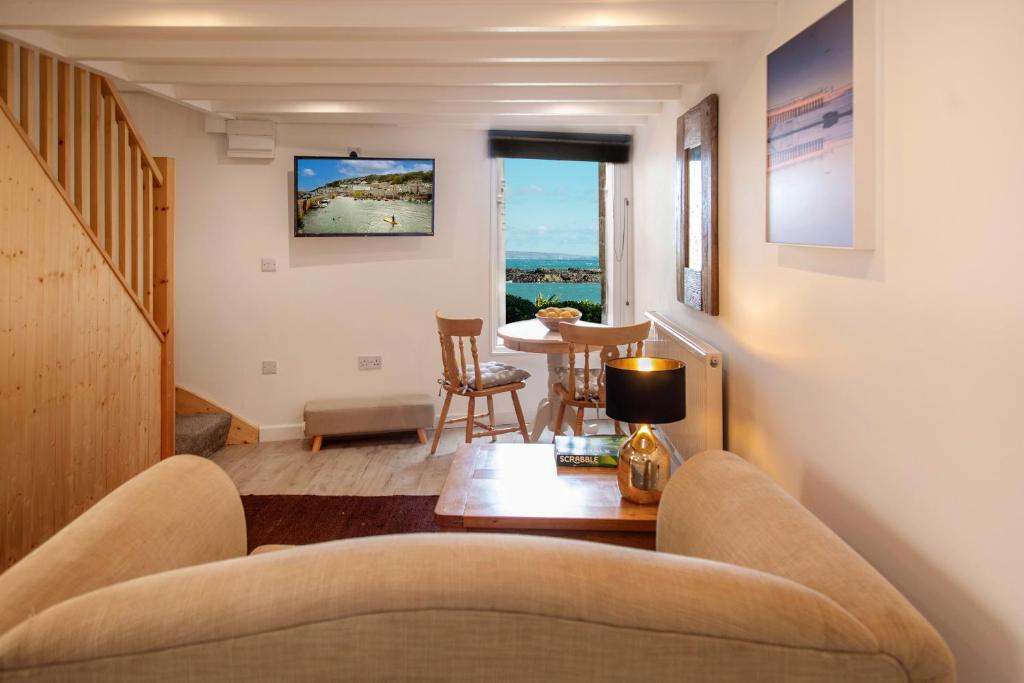 a living room with a couch and a table at Bijou Bolthole in Mousehole