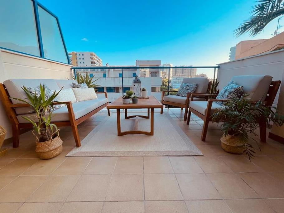 um pátio com sofás e uma mesa na varanda em Big terrace in modern apartment close to the beach em Oropesa del Mar