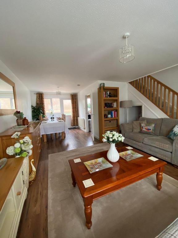 ein Wohnzimmer mit einem Sofa und einem Tisch in der Unterkunft ROSE COTTAGE in Ryde