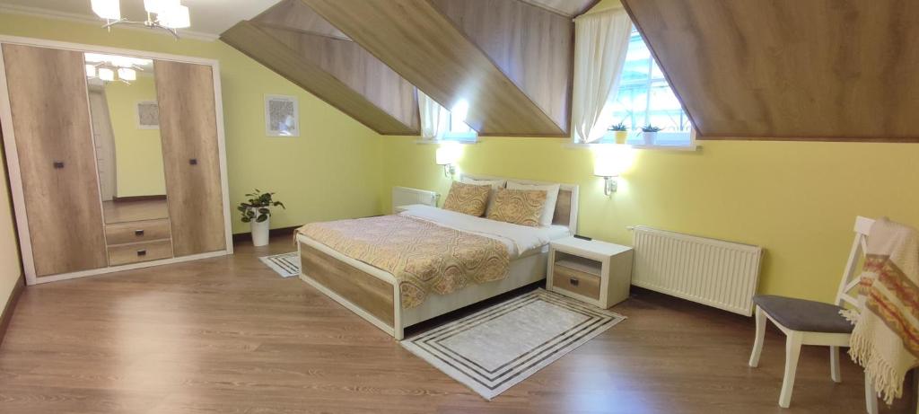 1 dormitorio con 1 cama en una habitación con paredes amarillas en Сонячна мансарда, en Kamianets-Podilskyi