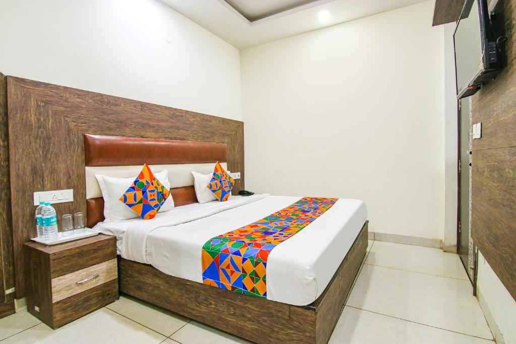 a bedroom with a large bed with a wooden headboard at FabHotel La Vista in Zirakpur