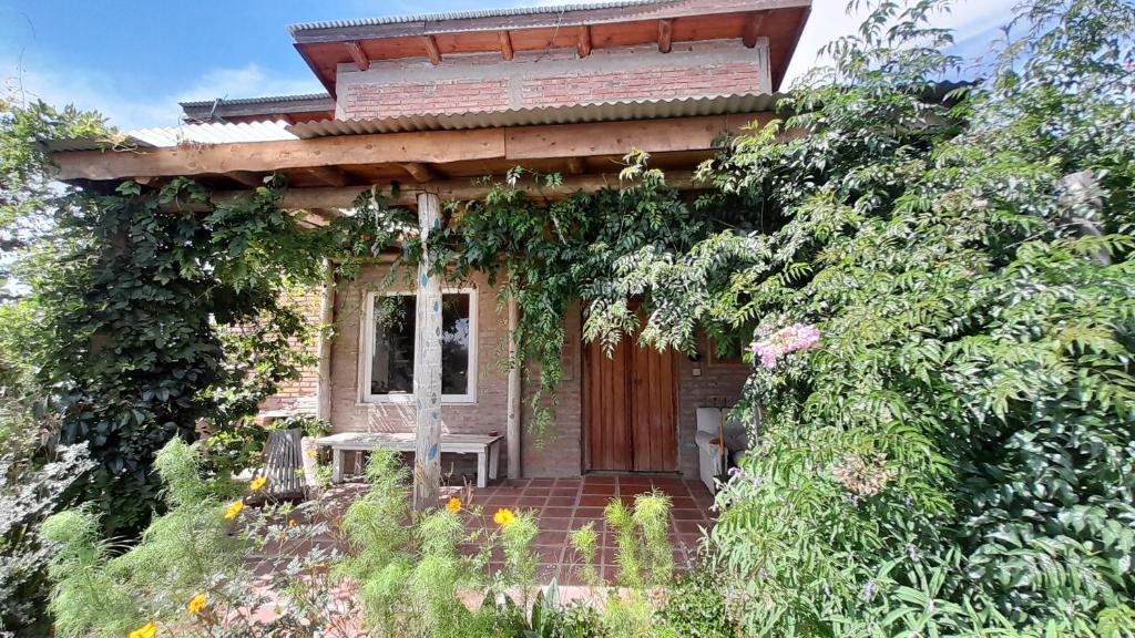 een klein huis met een houten deur en een bank bij CASA CIELO in Villa Berna