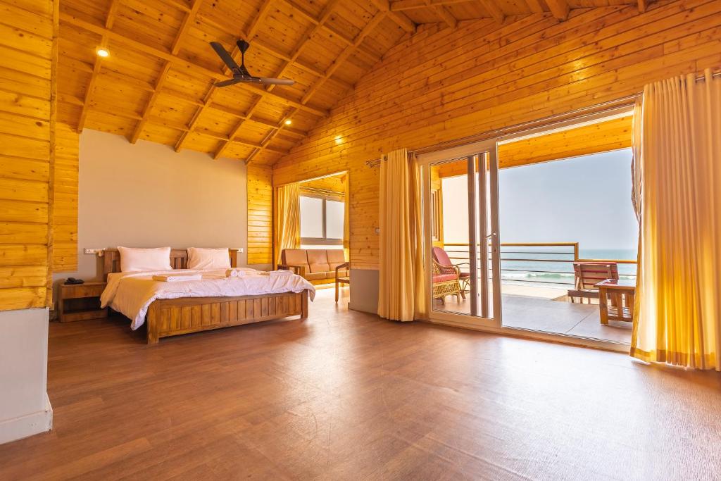 a bedroom with a bed and a view of the ocean at The O2H Agonda Beach Resort in Agonda