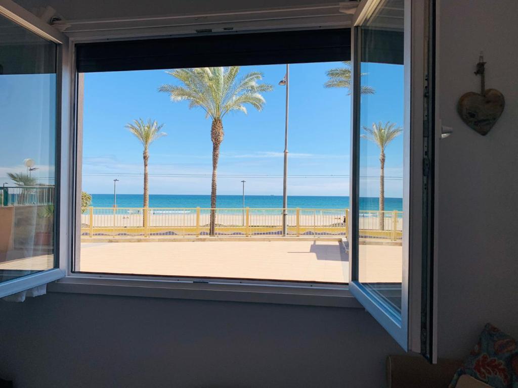 ventana con vistas a la playa y a las palmeras en GLP SAN JUAN BEACH, en El Campello