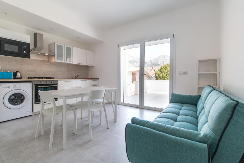 a living room with a blue couch and a table at Appartamento Perla Bianca, con WiFi e Air Con in Cala Gonone