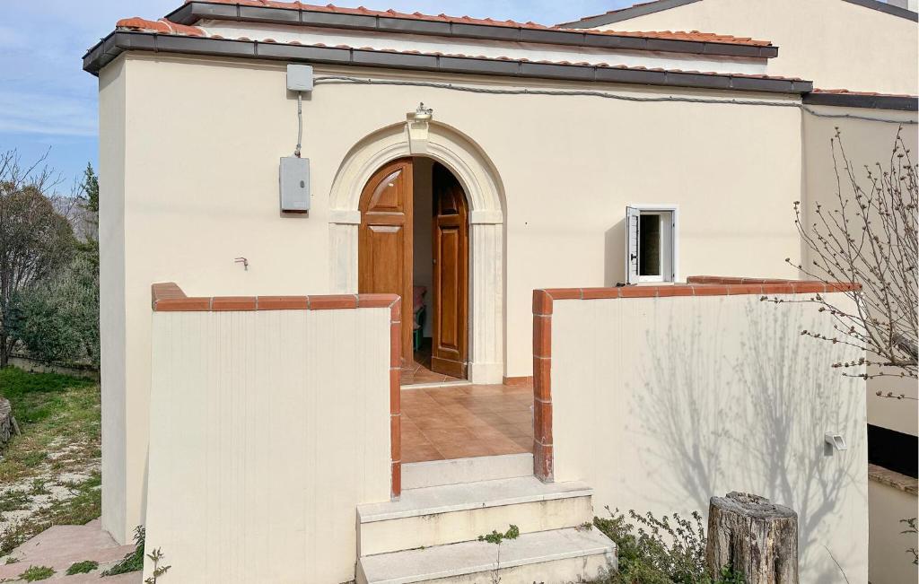 ein weißes Haus mit einer braunen Tür und einer Treppe in der Unterkunft 4 Bedroom Pet Friendly Home In Cugnoli in Cugnoli