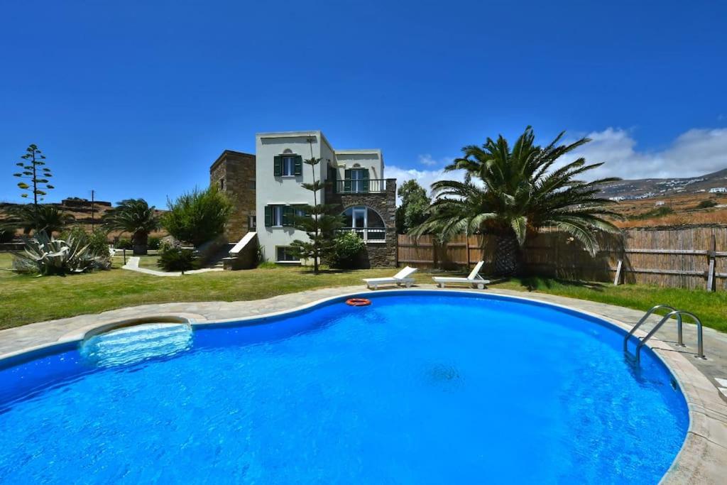 アギオス・ソスティスにあるLuxury Household in the Oustkirts of Tinos Townの家の前の青い大型スイミングプール