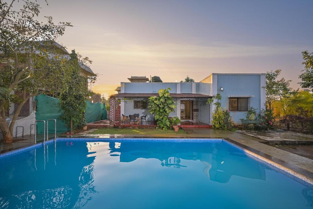 una casa con piscina frente a una casa en Landmark villa, en Malavli