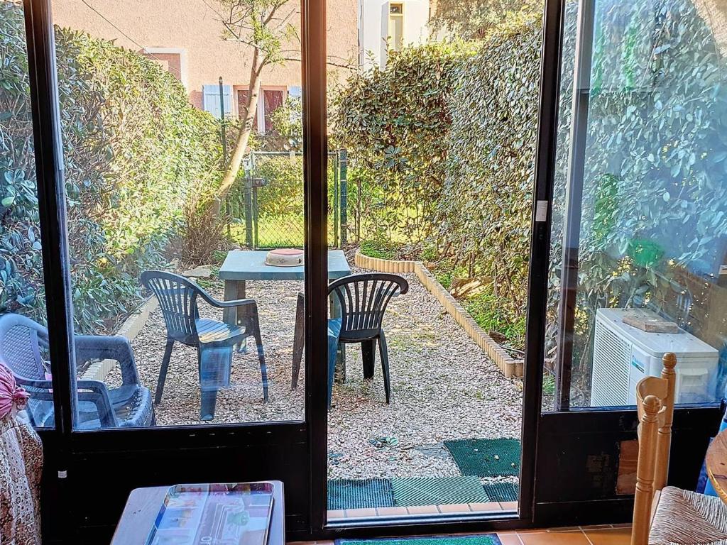 eine offene Tür zu einer Terrasse mit einem Tisch und Stühlen in der Unterkunft Appartement Bormes-les-Mimosas, 2 pièces, 4 personnes - FR-1-610-97 in Bormes-les-Mimosas