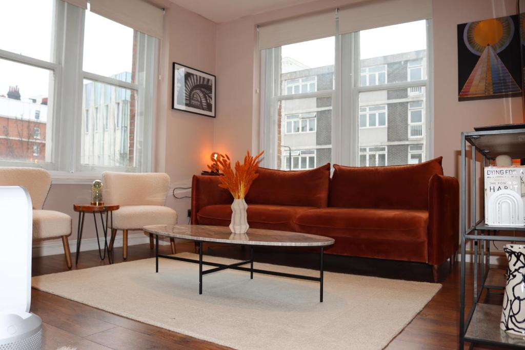 uma sala de estar com um sofá e uma mesa em Modern 2 Bedroom Apartment Notting Hill Gate/Kensington em Londres