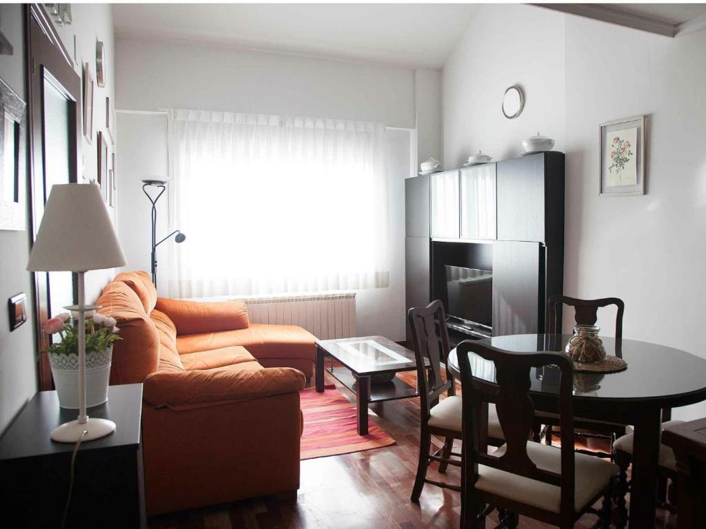 ein Wohnzimmer mit einem Sofa und einem Tisch in der Unterkunft Duplex Garonda in Pravia