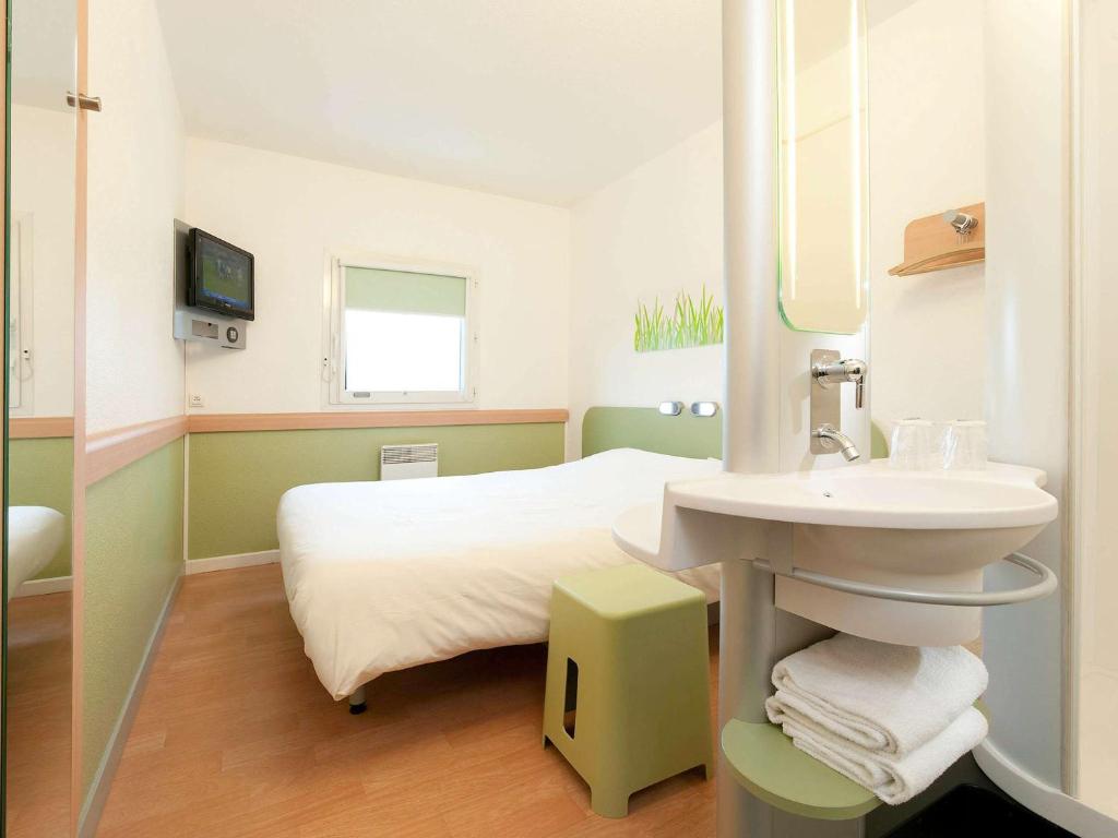 a hospital room with a bed and a sink at ibis budget Saint-Quentin Centre Gare in Saint-Quentin