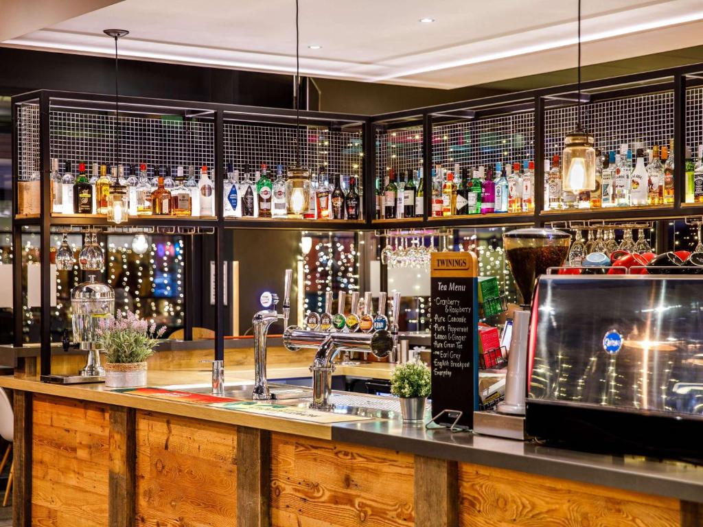 a bar with a counter with a lot of alcohol at ibis Bristol Centre in Bristol