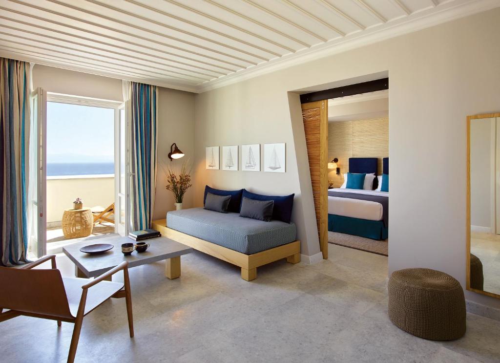 a living room with a bed and a couch and a table at Summer Senses Luxury Resort in Logaras