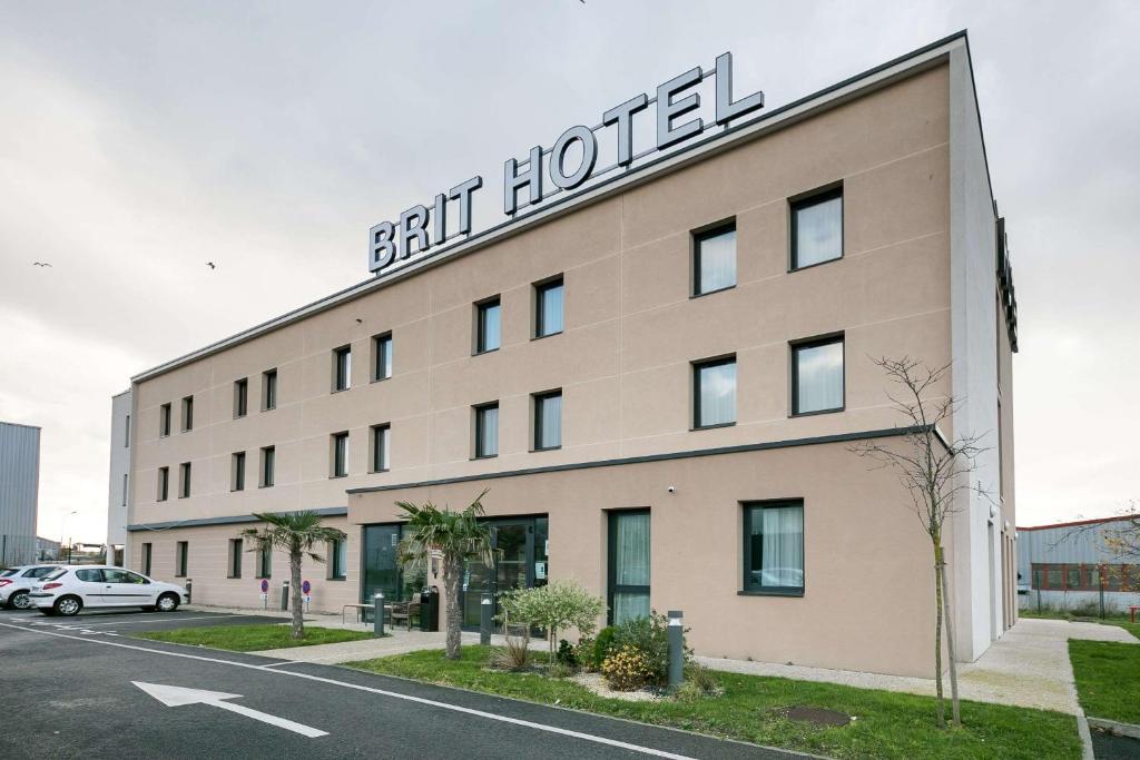 un hôtel avec un panneau sur le côté d'un bâtiment dans l'établissement Brit Hotel Dieppe, à Dieppe