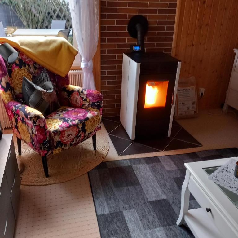 Una sala de estar con chimenea y un sofá. en Bungalow kleine Auszeit, en Stiege