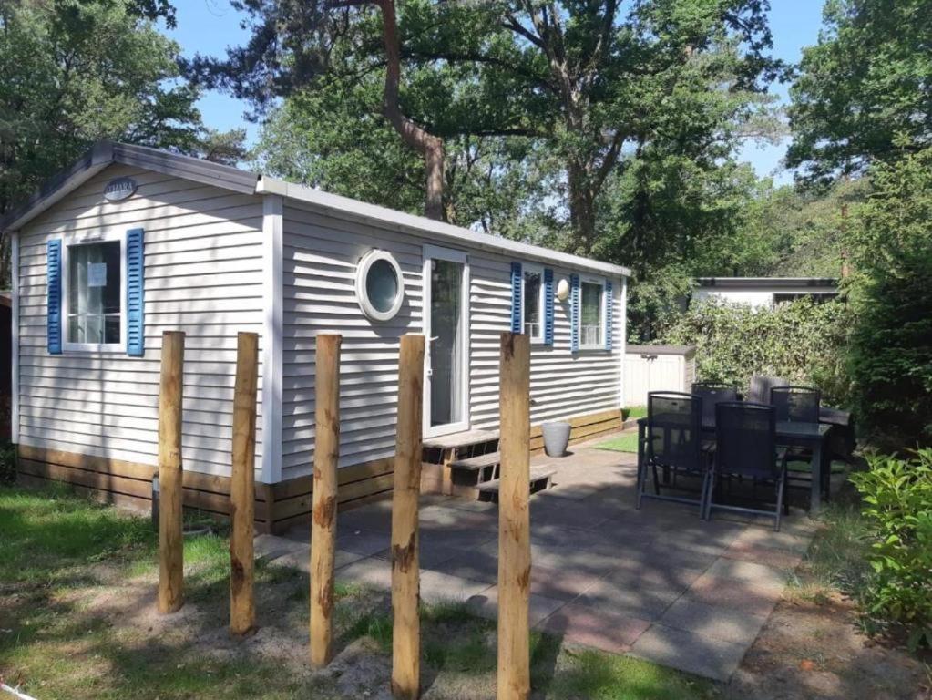 a tiny house with a table and a fence at Chalet vakantiepark Kleine Belties 18 in Hardenberg