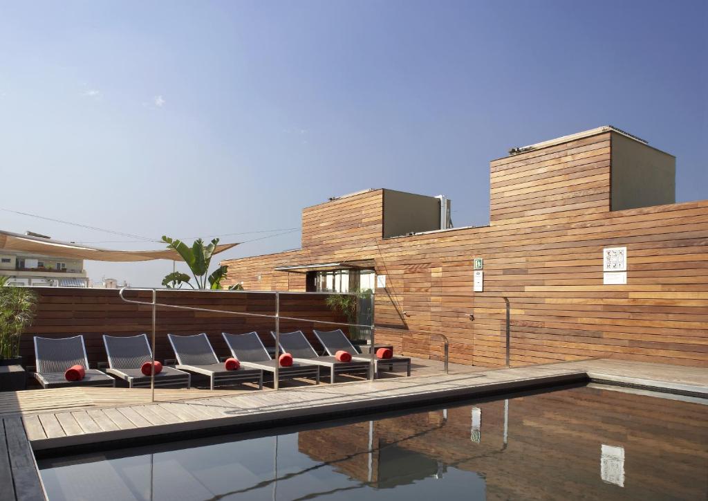 a row of wooden benches in front of a large building at Hotel Soho in Barcelona