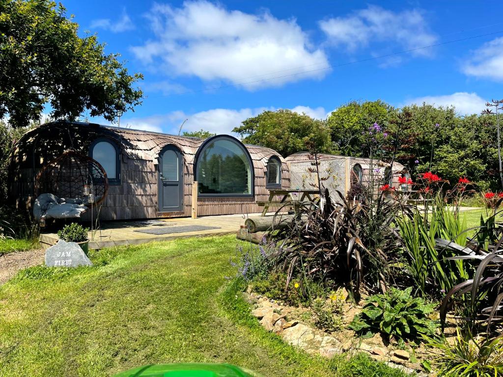 a house with an arched window in a garden at Jam First - Lydcott Glamping, Cornish Sea Views in East Looe