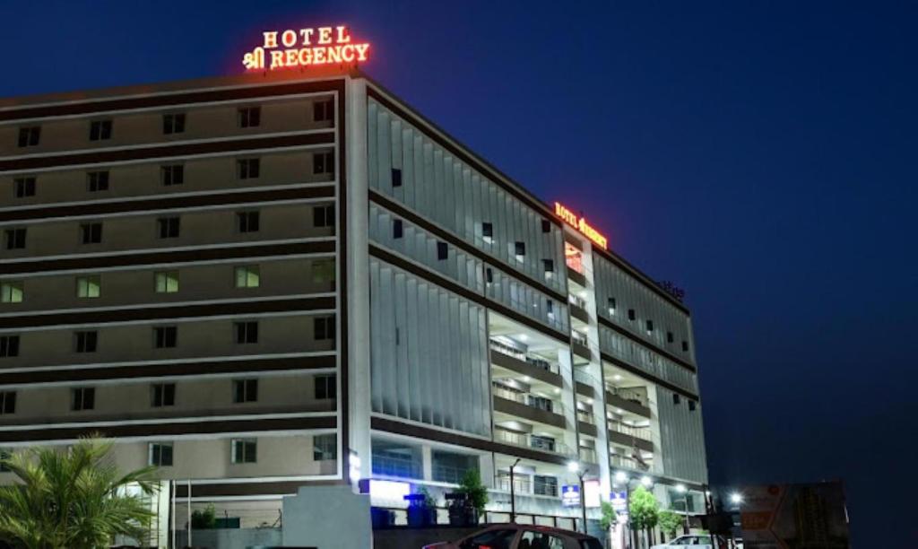 アーメダバードにあるHotel Shree Regency Ahmedabadのネオンの看板が立つ建物