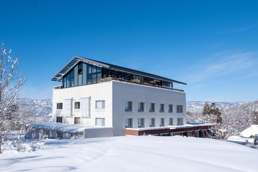 un bâtiment au sommet d'une colline enneigée dans l'établissement HOKURYUKO HOTEL North NAGANO, à Iiyama