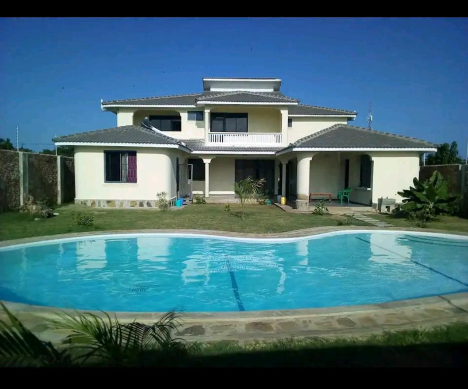 a house with a swimming pool in front of it at Lisa in Mombasa