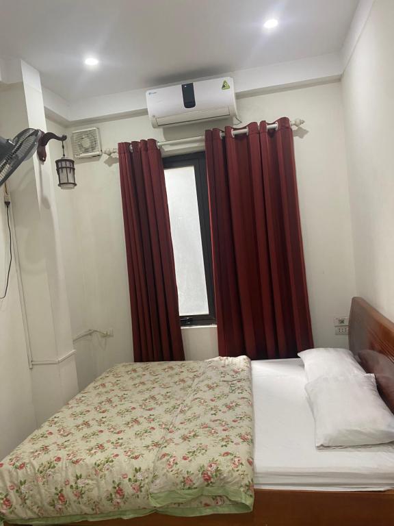 1 dormitorio con 1 cama con cortinas rojas y ventana en Phòng đơn có cửa sổ thoáng mát khép kín + Thang máy, en Hanói