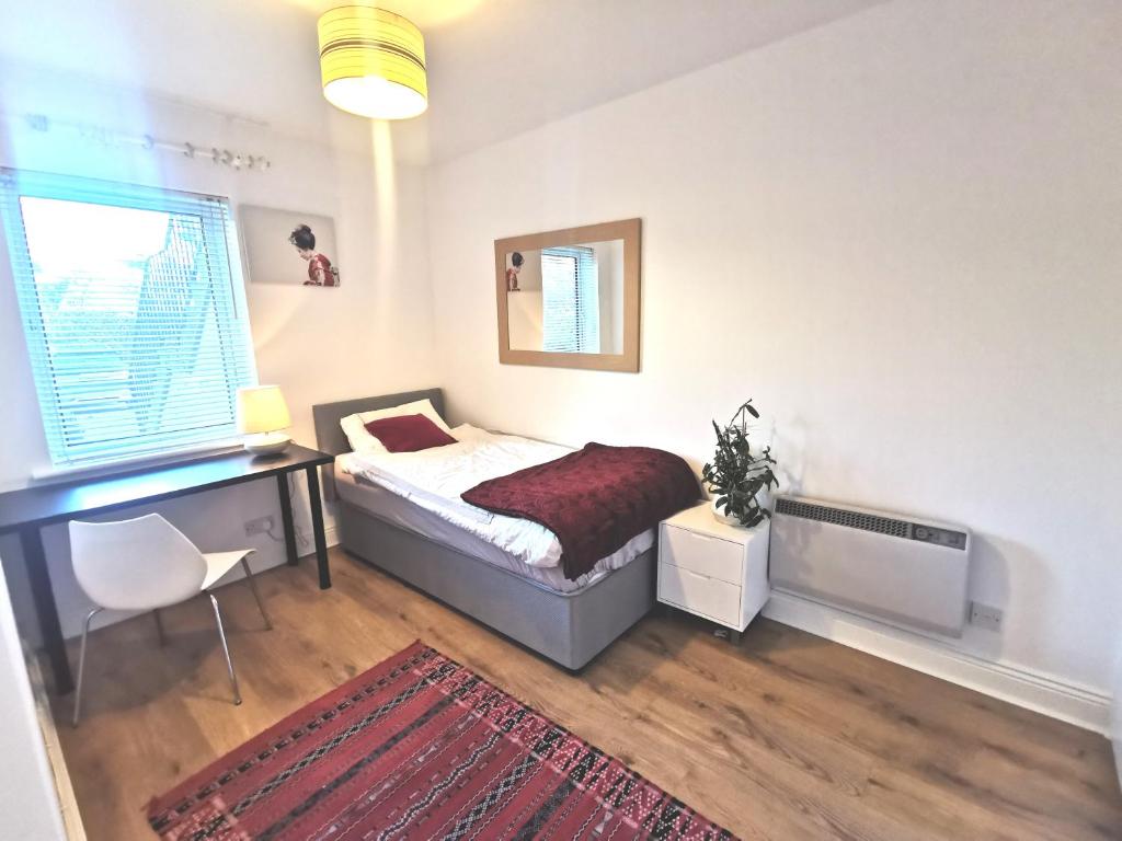 a bedroom with a bed and a desk and a window at Charming apartment with big terrace in Sandymount in Dublin