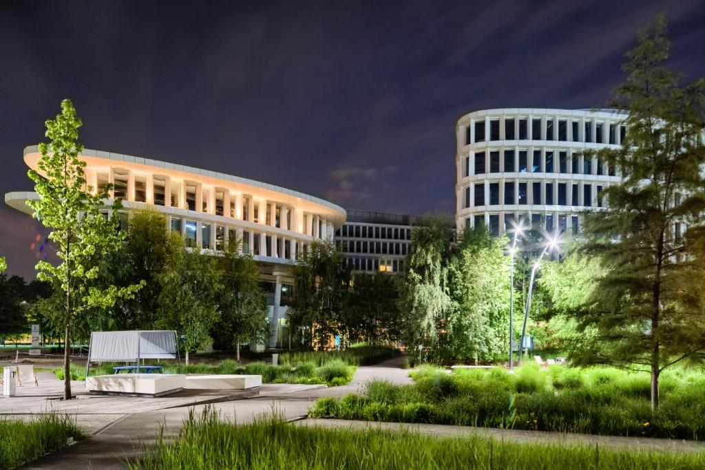 un bâtiment avec un parc en face de lui la nuit dans l'établissement Sound Garden Hotel Airport, à Varsovie