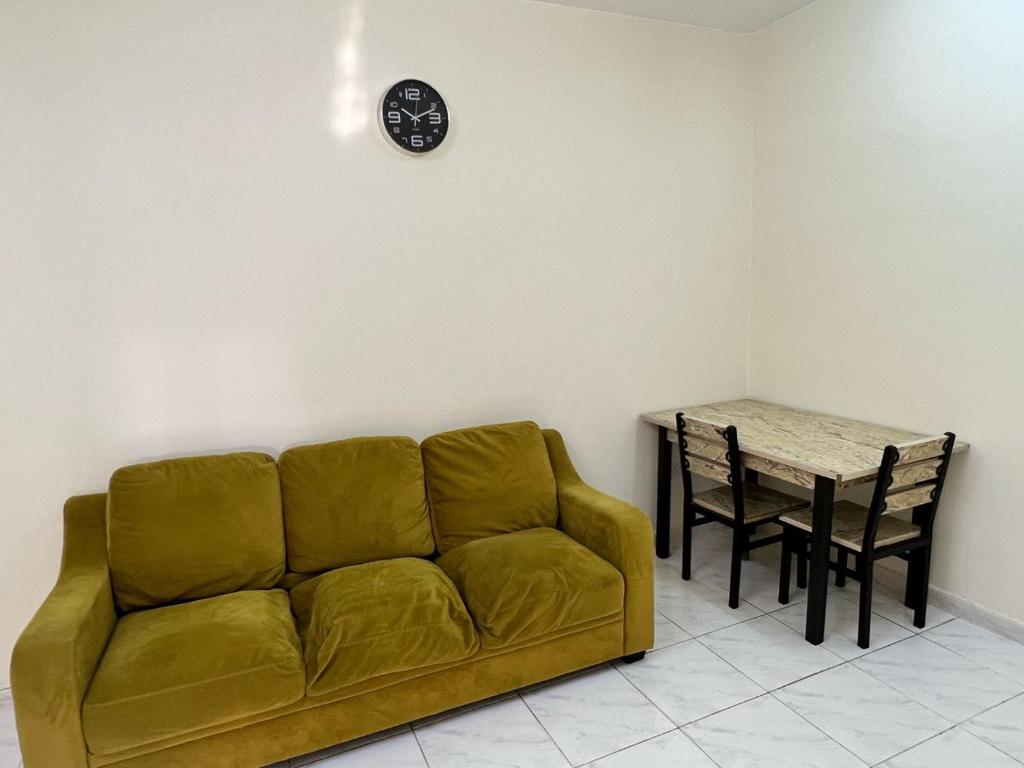 - un salon avec un canapé et une table dans l'établissement dafza metro Home, à Dubaï