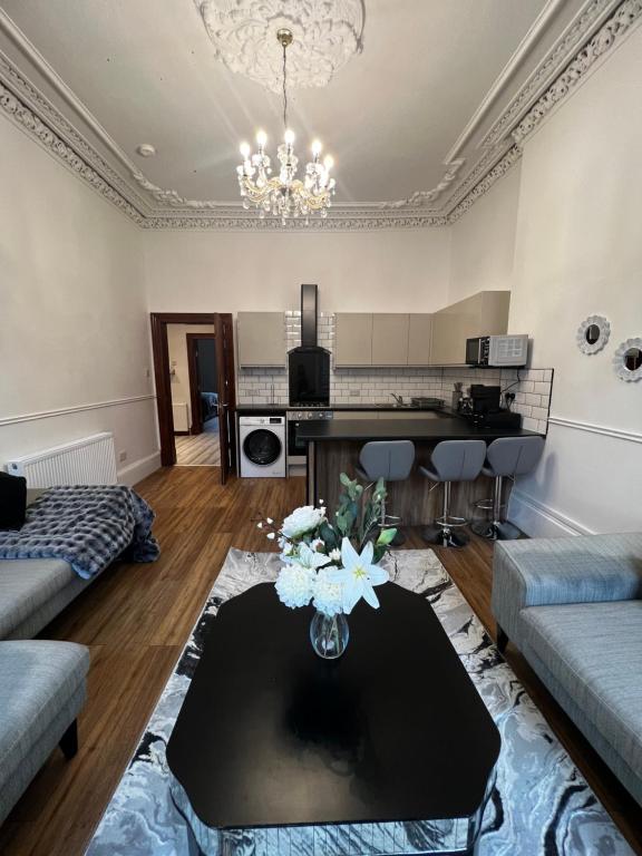 a living room with a couch and a table at Sauchiehall Street Apartment in Glasgow