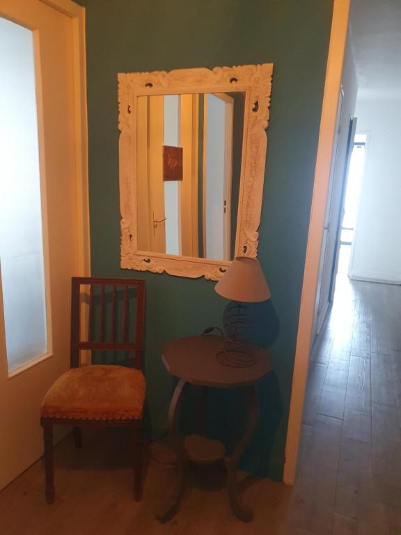 Cette chambre comprend un miroir, une table et une chaise. dans l'établissement L'atelier cosy, à Beaune