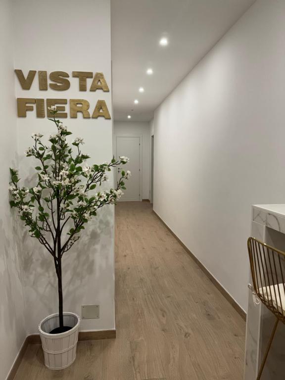 einen Flur mit einer Pflanze in einem Topf neben einer Wand in der Unterkunft Vista Fiera Bologna in Bologna