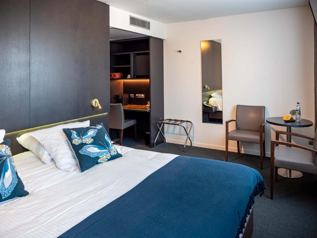 um quarto de hotel com uma cama, uma mesa e cadeiras em Tower Hotel Aalst em Aalst