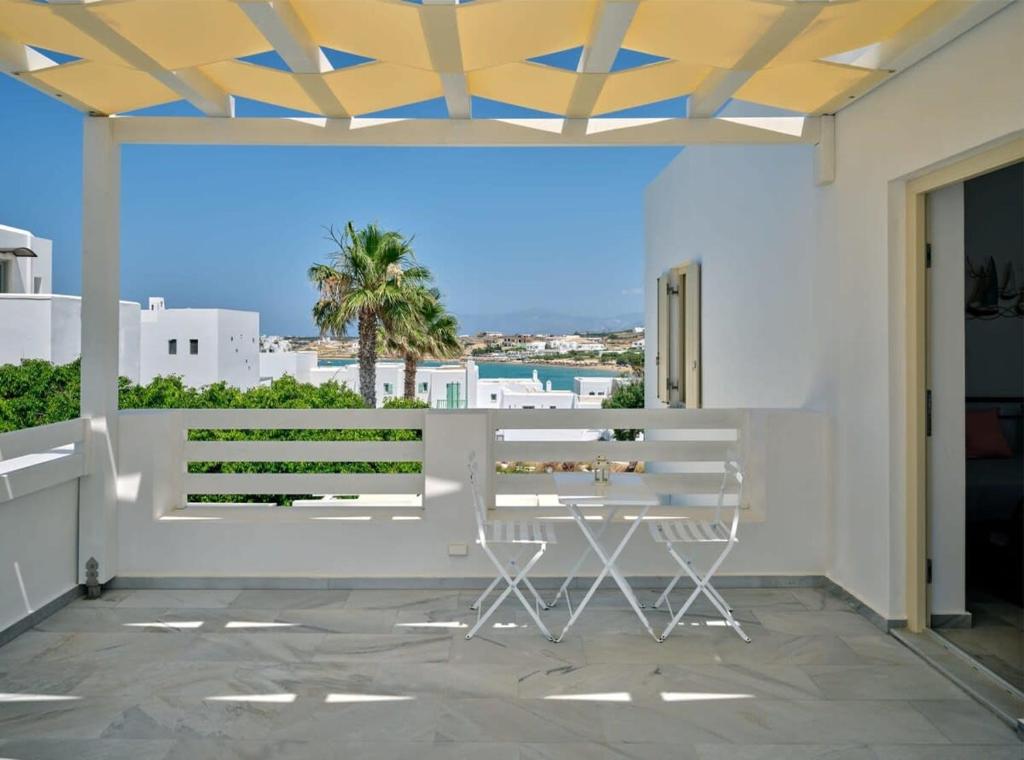 a patio with a table and a view of the ocean at Villa Maria - Naoussa Boats Blue & Sandy Suite in Naousa