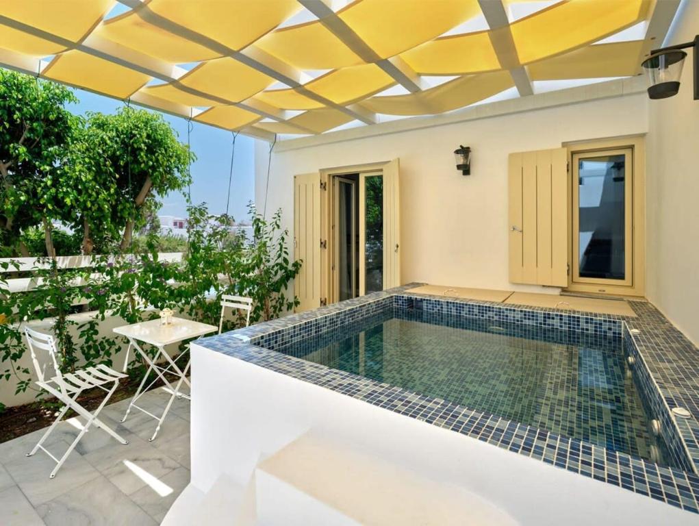 a swimming pool in a house with a table and chairs at Villa Maria - Naoussa Surfers Bluewave Suite in Naousa