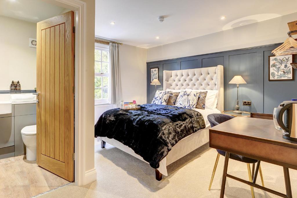 a bedroom with a king sized bed and a desk at The Bridge House Henley in Henley in Arden