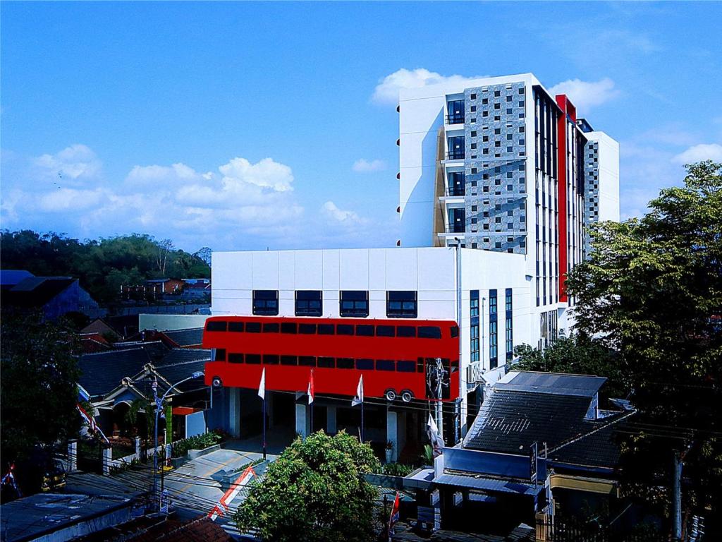 a large white building with a red stripe on it at Hotel Fortunagrande Jember in Jember