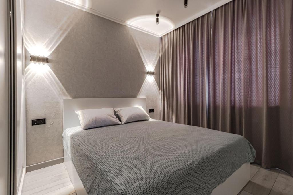 Un dormitorio con una cama con luces. en Улучшенные апартаменты в центре города en Promyshlennyy