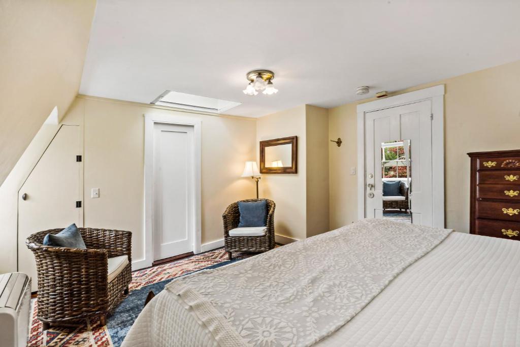 a bedroom with a bed and two chairs in it at Marshall Slocum Inn in Newport
