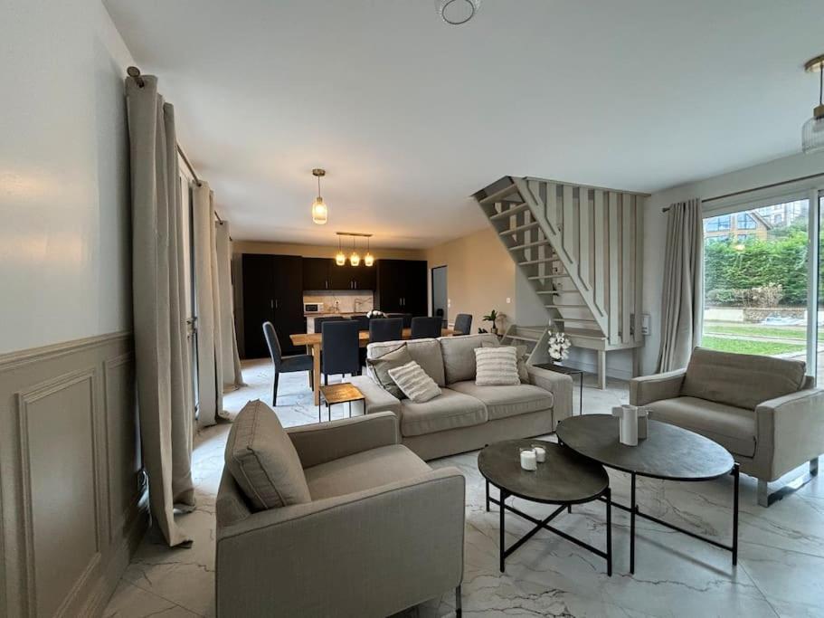un salon avec des canapés et des tables ainsi qu'un escalier dans l'établissement Les Villas de Puys : Luxueuse Villa 7-9Pers, à Dieppe