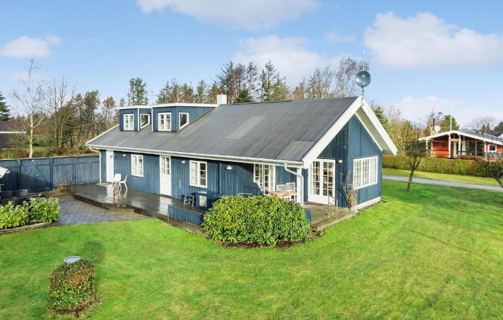 uma casa azul com um telhado cinzento num quintal em 3 Bedroom Pet Friendly Home In Hjslev em Højslev