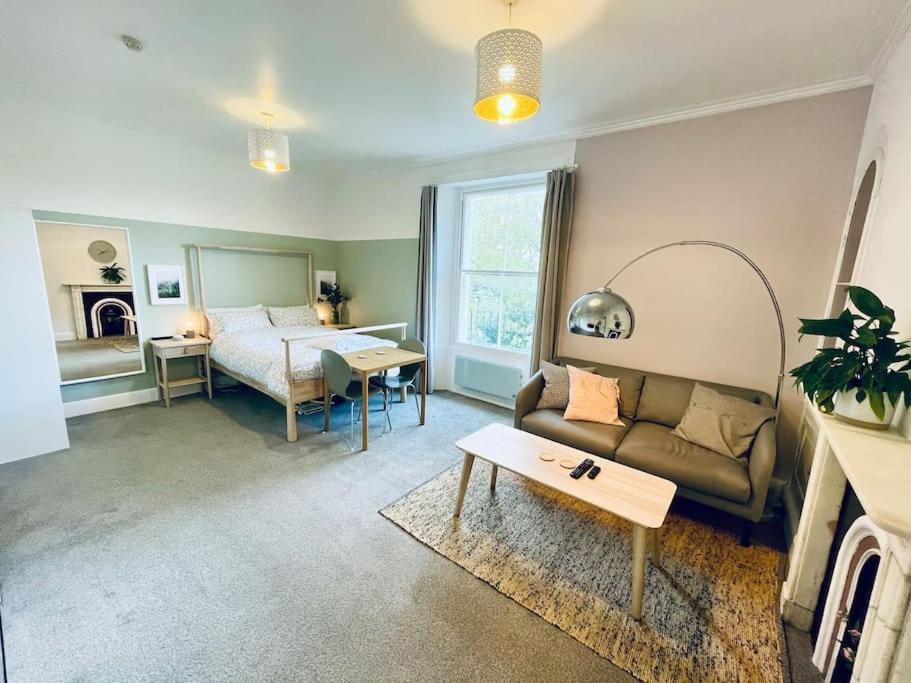 a living room with a bed and a couch at Central studio flat with parking permit in Bath