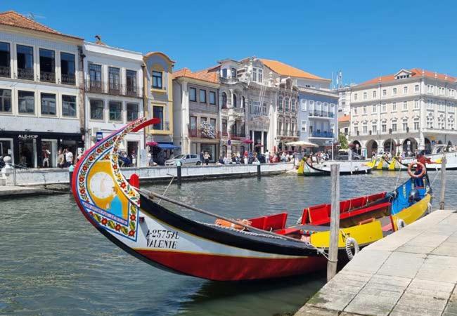 a boat is docked next to a canal with buildings at Casa Rosa Aluguel de Quartos in Calvão